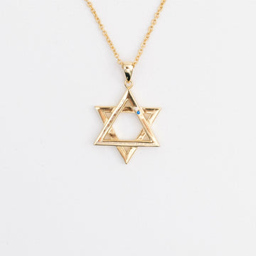 A gold-colored Star of David necklace with a small blue gem at its center, displayed against a white background.